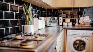 Une cuisine équipée d’une cuisinière, d’un four à micro-ondes et d’un lave-linge.