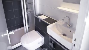 Un baño moderno con ducha, inodoro y lavamanos.