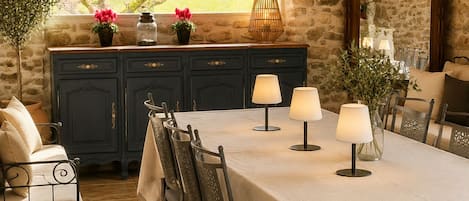 Comedor con pared de piedra, un amplio ventanal con vistas y una mesa dispuesta para seis personas con sillas.
