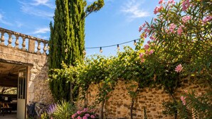 A stone wall with a bench, potted plants, and a pergola with string lights. - Le Mas d'Eylieux - Les Citronniers - Les Citronniers - Escapade in Southern Ardèche (Saint-Montan)