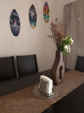 A dining table with a vase of flowers and a sign that reads 'EAT ME'. - Casa Atardecer (Playa del Carmen) Los Olivos (Playa del Carmen)