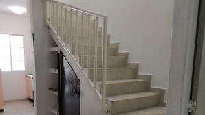 A staircase with a wooden bench at the bottom, leading to a landing with a door. - Casa Atardecer (Playa del Carmen) Los Olivos (Playa del Carmen)