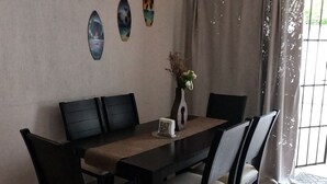 A dining area with a dark wooden table, six chairs, and a vase with flowers. - Casa Atardecer (Playa del Carmen) Los Olivos (Playa del Carmen)