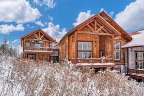 A wooden cabin with a balcony, large windows, and a snow-covered landscape. - Homestake Slopeside Chalet at Terry Peak (Lead)