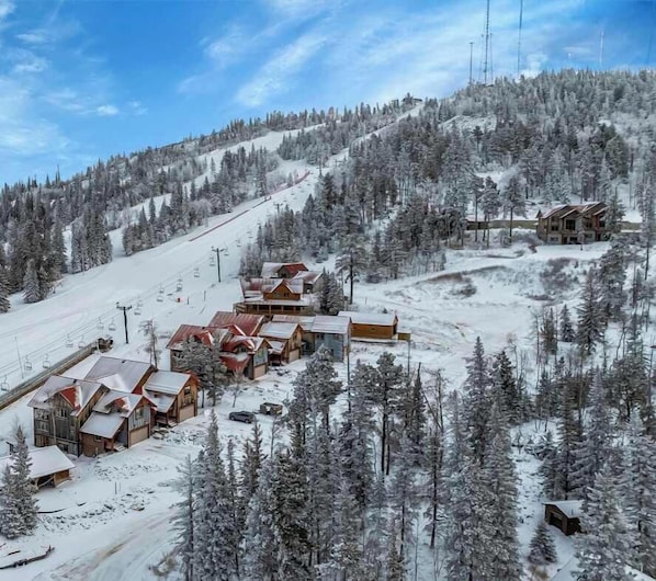 A snow-covered ski resort with wooden cabins and a ski lift. - Homestake Slopeside Chalet at Terry Peak (Lead)