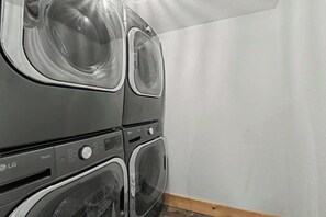 A stacked washer and dryer unit with a control panel and a transparent door.