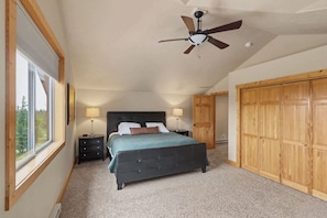 A bedroom with a bed, two bedside tables with lamps, a ceiling fan, and a large wooden wardrobe. - Homestake Slopeside Chalet at Terry Peak (Lead)