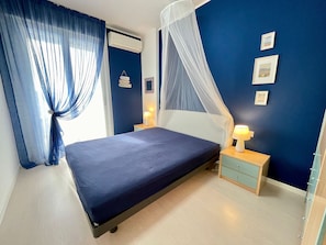 Une chambre à coucher avec un lit, des tables de chevet, un baldaquin et des éléments décoratifs sur les murs.
