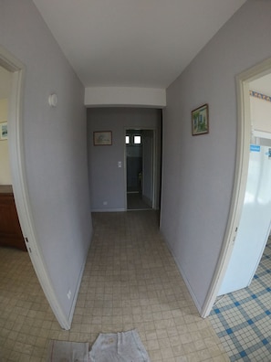 A hallway with a tiled floor, a door on the right, and a door at the end leading to another room. - Gite l'Escale in Vielmur sur Agout sleeps 4 (Vielmur-sur-Agout)
