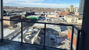 A balcony with a view of a cityscape, including buildings and a parking lot. - Condo Downtown (Beltline) w/ Underground Parking (Calgary)