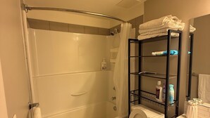 A bathroom with a bathtub, toilet, and a shower area. - Condo Downtown (Beltline) w/ Underground Parking (Calgary)
