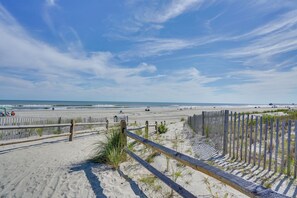 A beach with a wooden fence, sandy dunes, and a clear sky. - Family Beach Getaway 1 block to Beach & Boardwalk (Ventnor City)