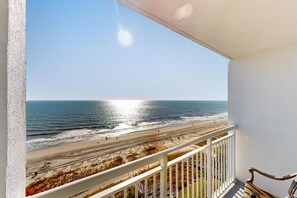Een balkon met uitzicht op een strand en zee.