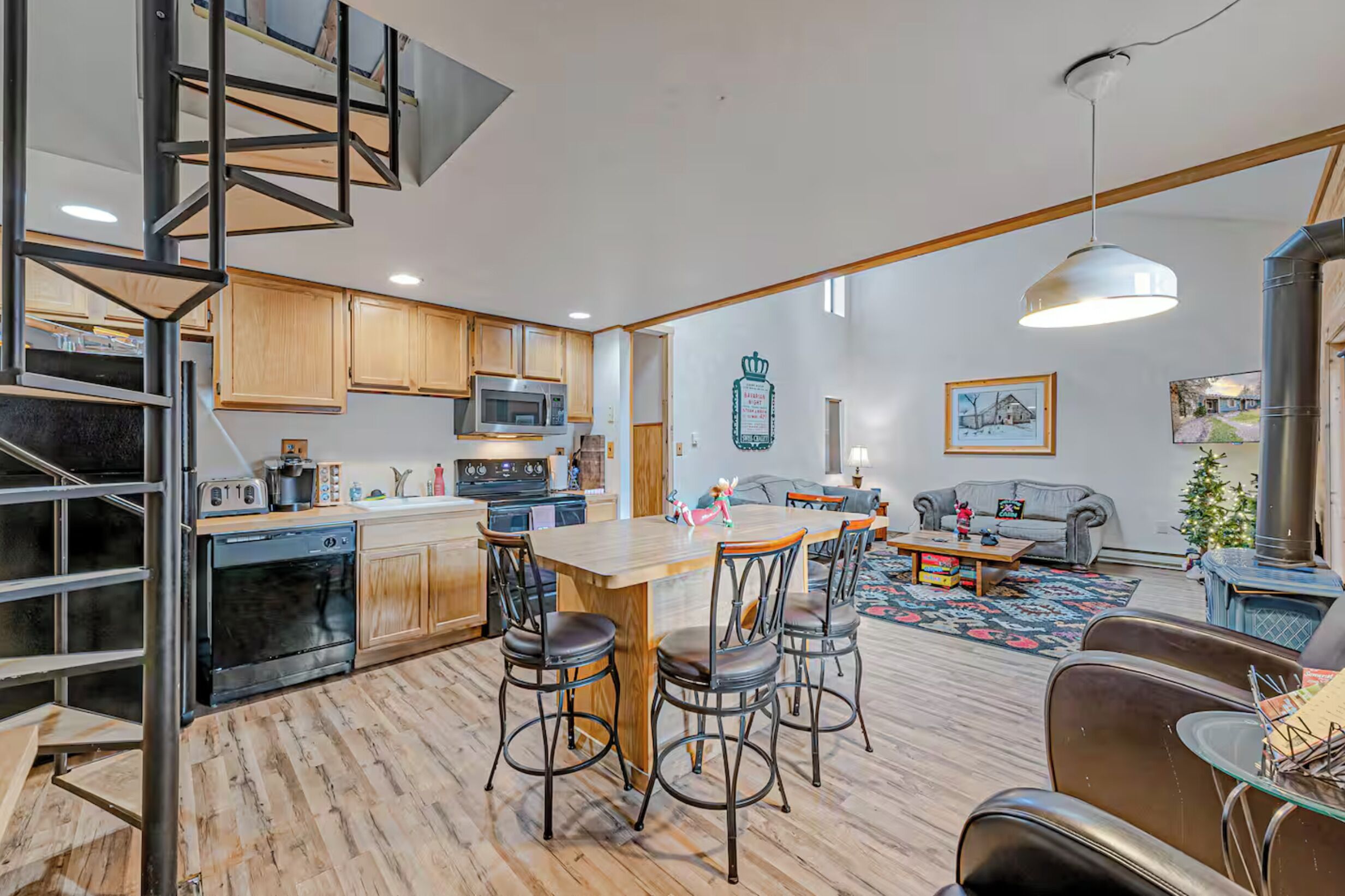 A modern kitchen with a central island, wooden cabinets, and a built-in oven.