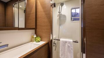 A bathroom with a shower, a sink, and a mirror.