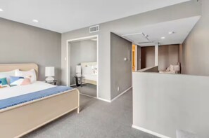 A modern hotel room with a bed, bedside tables, a desk, and a chair. - Fun & Hip Apt Downtown Austin - 2 BR/3 Beds (Austin)