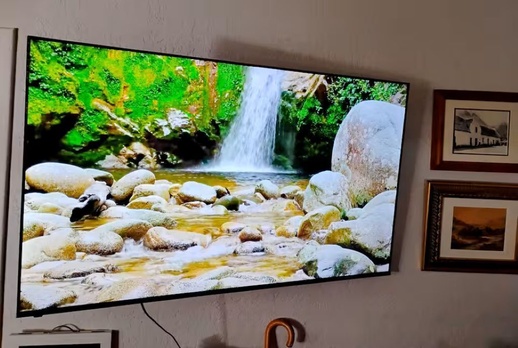 Un téléviseur fixé au mur affiche une scène de cascade.