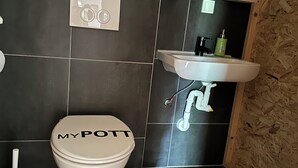 Ein Badezimmer mit Toilette, Waschbecken und Spiegel.