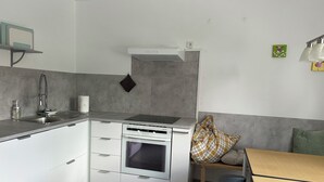 Eine kleine Küche mit eingebautem Backofen, Spüle und Herd.