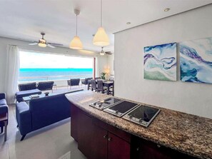 Cuina moderna amb taulell de granat, dues vitroceràmiques i zona de menjador amb vista a l'oceà.