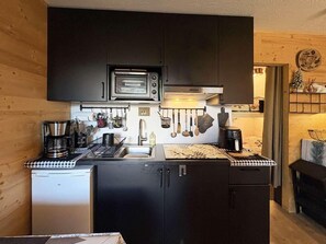 A compact kitchen with a built-in microwave, coffee maker, and a small refrigerator. - Ground floor, view mountain, balcony, tv, ski locker, 23m², Les Orres (Les Orres)