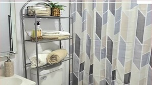 A bathroom with a white toilet, a metal shelf with towels and toiletries, and a shower curtain with a geometric pattern. - #33 Private in law suite near USF (Tampa)