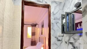 Een badkamer met toilet, wastafel en douche.