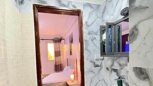 Een badkamer met toilet, wastafel en marmeren wanden.