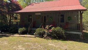 A two-story house with a red roof, a porch with a railing, and a front door. - Nature Oasis | Hot Tub | Fishing Pond | Fire Pit (Mentone)