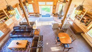 Un intérieur de chalet chaleureux avec un canapé en cuir, une table à manger en bois et une cheminée.