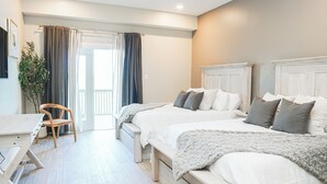 A bedroom with two beds, a desk, a chair, and a potted plant. - Hotel Whiskey in Long Beach (Long Beach)
