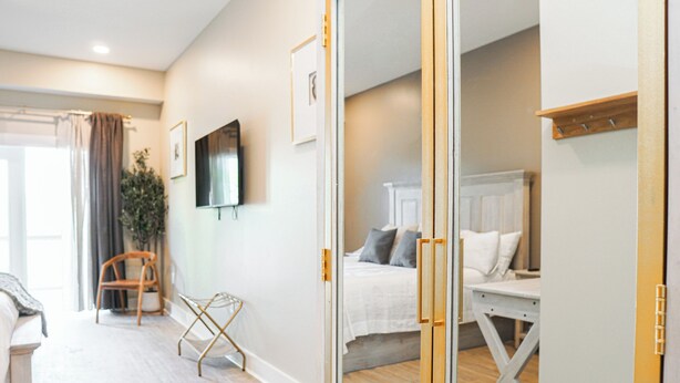 A modern bedroom with a bed, bedside table, and a chair. - Hotel Whiskey in Long Beach (Long Beach)
