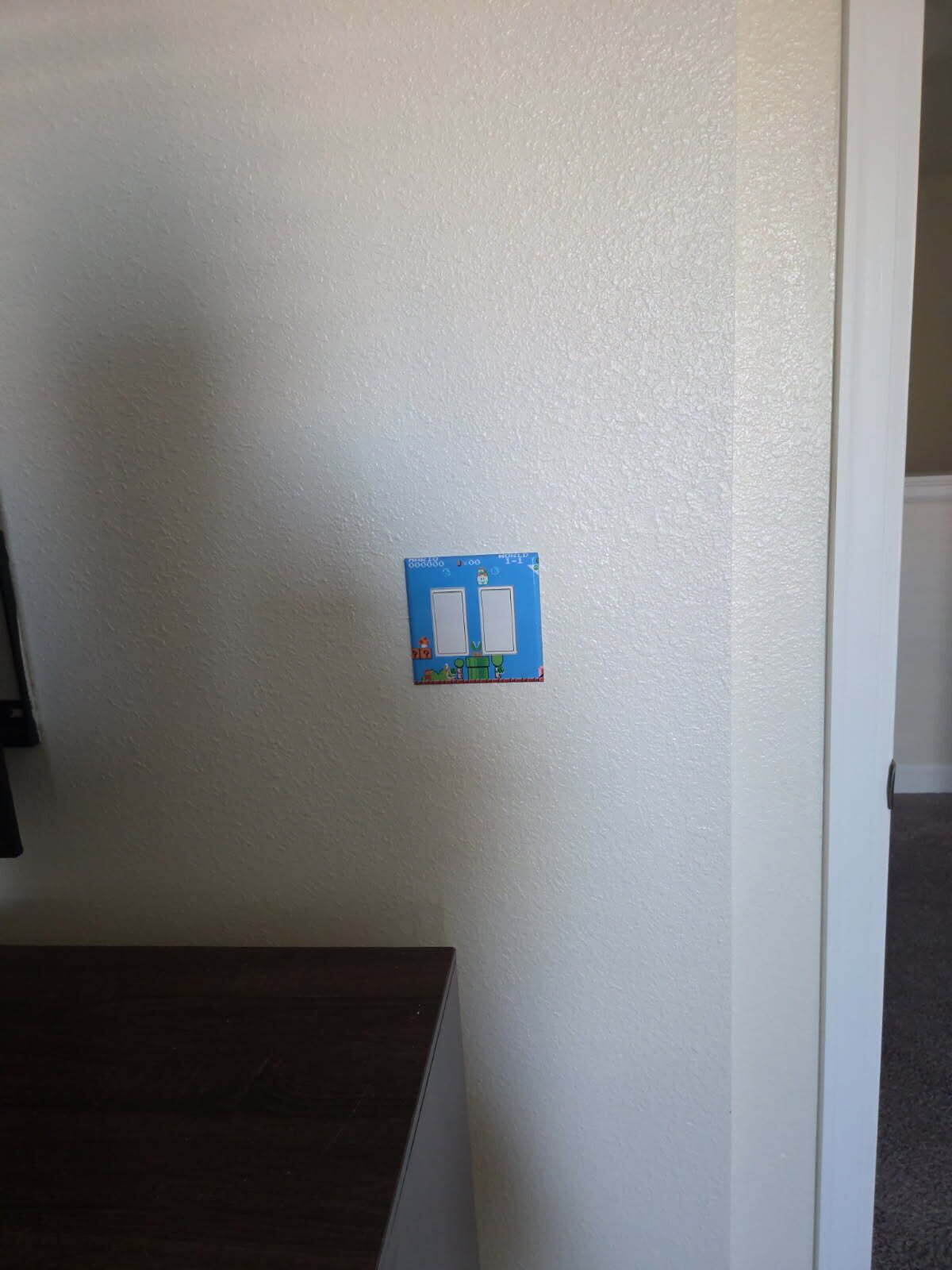 Una pared blanca con un cuadro de interruptores eléctricos azules.