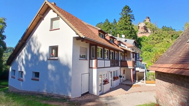 A two-story house with a sloped roof, multiple windows, and a balcony. - In the heart of nature - Gîtes 15 people (Windstein)