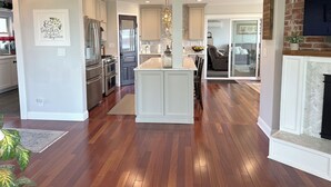 Una cocina moderna con una isla central, un comedor y una sala de estar con chimenea.