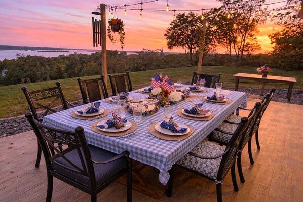 Un espace de restauration en plein air avec une table dressée pour six personnes, entourée de chaises, et offrant une vue panoramique.