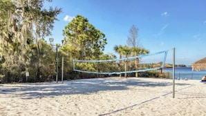 A beach volleyball court with a net, surrounded by trees and a clear sky. - 3BR resort condo: Hot tub, pools, lake access (Davenport)