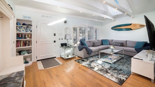 Ein modernes Wohnzimmer mit einer Couch, einem Couchtisch und einem Bücherregal mit Büchern und Helmen.