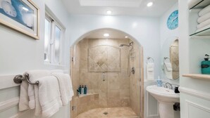 Ein Badezimmer mit Dusche, Waschbecken und Handtuchhalter.