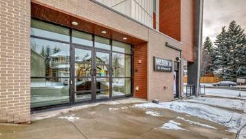 A building with a large glass entrance, a brick facade, and a sign reading 'MISSION 34'.