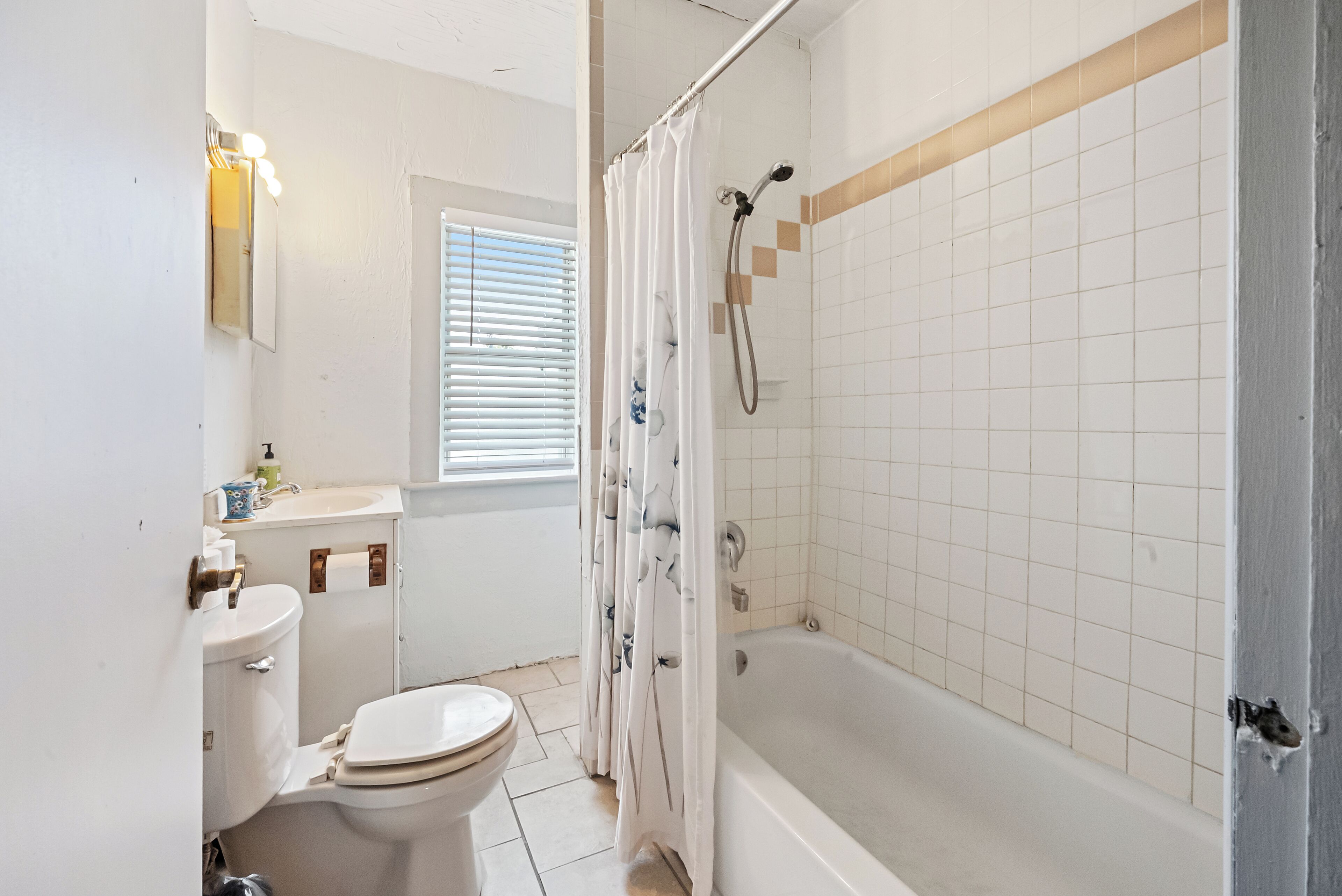 A bathroom with a toilet, sink, and bathtub.
