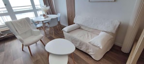 Ein modernes Wohnzimmer mit einer Couch, einem Sessel und einem runden Tisch.