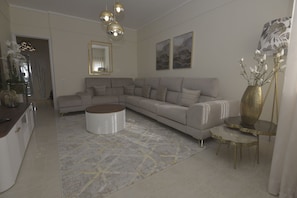 Ein Wohnzimmer mit Ecksofa, rundem Couchtisch und einer dekorativen Vase.
