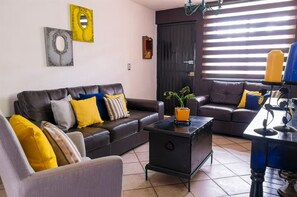 Una sala de estar con sofá, sillón y mesa de centro.