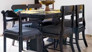 A dining area with a round table, four chairs, a ceiling fan, a framed picture on the wall, and a window with a view. - Casa AMAR-i-LLA - Centrally located and with A/C (Guadalajara)