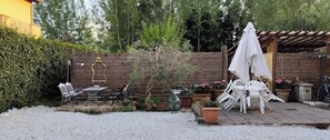 A patio area with outdoor furniture, a pergola, and potted plants.