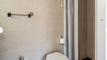 Ein Badezimmer mit Toilette, Bidet und Duschbereich.