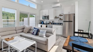 A modern kitchen with white cabinetry, a stainless steel refrigerator, and a built-in oven. - De La Float - Floating House on Lake Cumberland (Russell Springs)