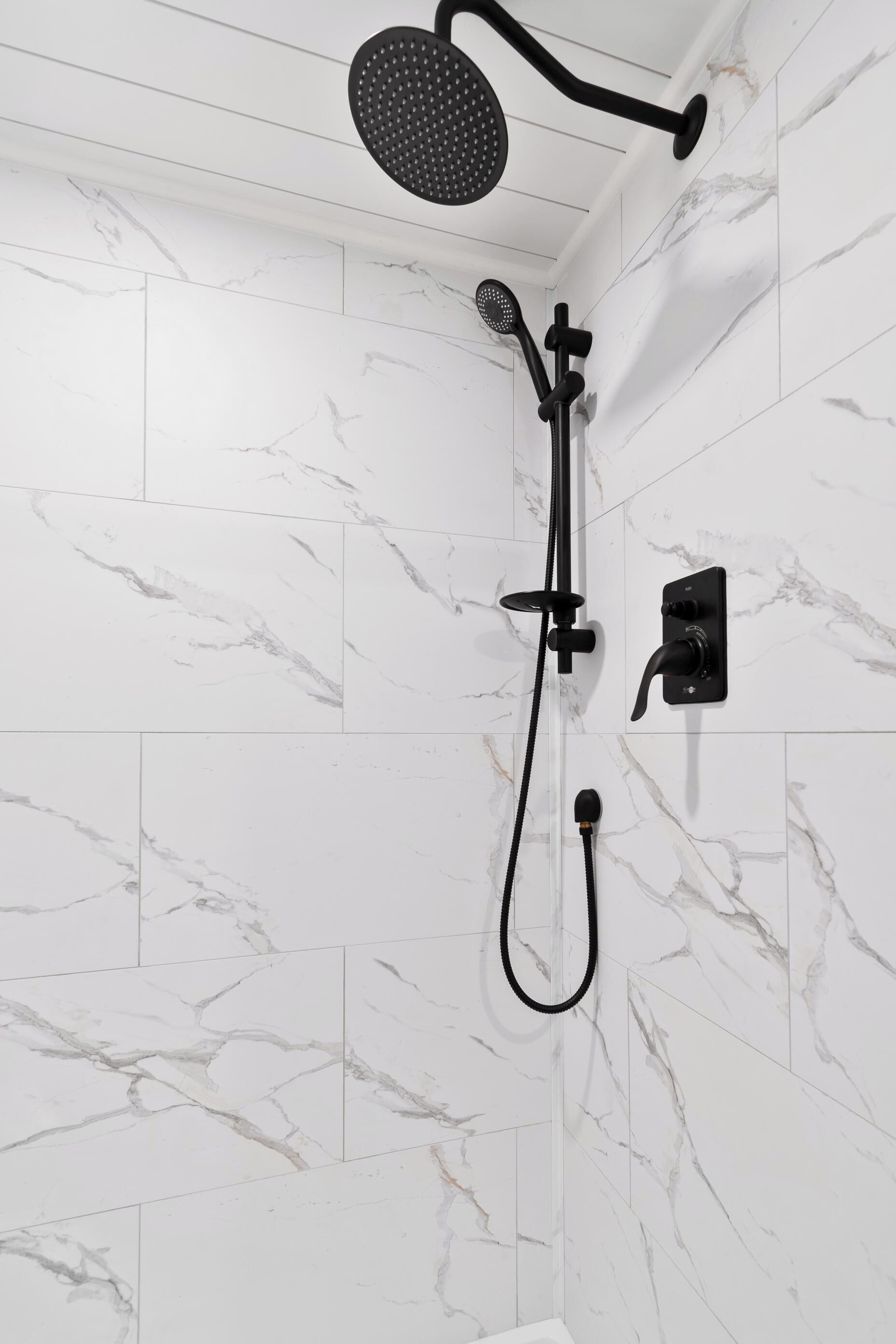 Eine Dusche mit Handbrause und einer fest installierten Bedienkonsole.