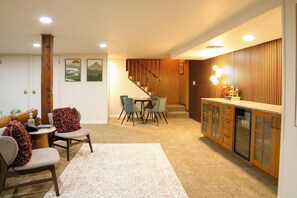 A home interior with a dining area, kitchen, and staircase. - Midcentury Riverfront Retreat (Lansing)